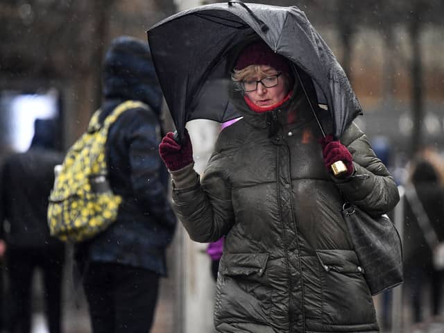 Woman walks in stormy conditions.