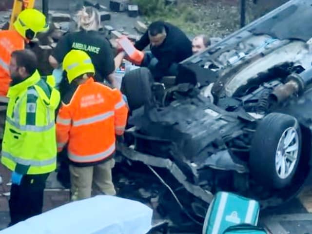 Footage of the aftermath of a car crash that left two pedestrians hospitalised shows a man being pulled from the wreckage.  