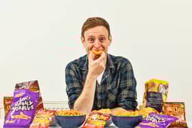 Aldi Chief Crisp Tasting Officer George Critchley with a range of Aldi own brand crisps. (Photo: PR Handout)