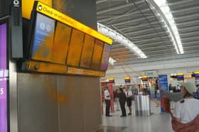 Just Stop Oil cover Heathrow Airport Terminal 5's departure boards in orange paint.