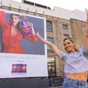 Ashley puts sweat shame to sweat fame by standing in front of her sweating billboard as the new face of Extra Flamin' Hot snacks