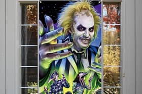 Beetlejuice themed Halloween decorations like this door cover are all the rage this year