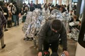 Evacuated Gatwick Airport passengers wrap themselves in foil blankets.
