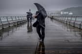 People battle against the wind and rain.