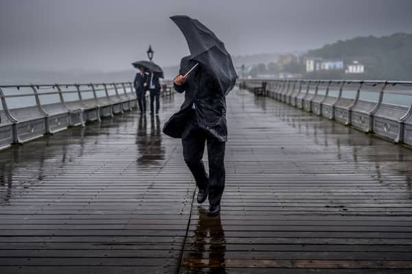 People battle against the wind and rain.