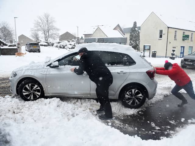 Stock image of car being pushed out of snow.