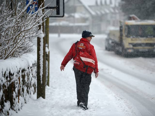 A postman makes his way through the snow.