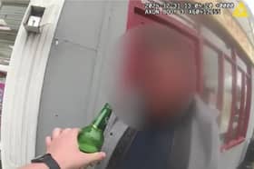 Man tries to take swig of his lager while being arrested for drink driving.