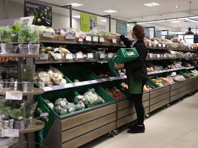 An employee stacks shelves at a Waitrose supermarket (Photo: HOLLIE ADAMS/AFP via Getty Images)