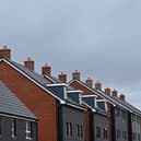 An electricity pylon is pictured beyond newly built residential properties at a construction site for new houses and homes near Aylesbury in July 2023 (Photo: JUSTIN TALLIS/AFP via Getty Images)