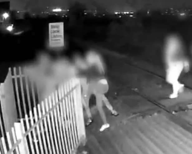 Men hold shut gates of level crossing in Barnsley, South Yorkshire.