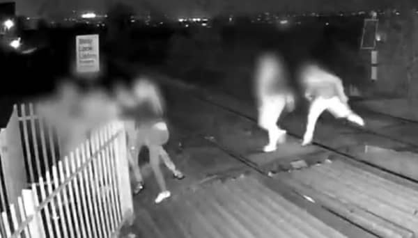 Men hold shut gates of level crossing in Barnsley, South Yorkshire.