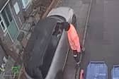 Car drives along pavement to get past bin lorry.
