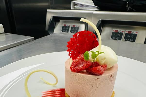 A beautifully plated raspberry parfait—delicately balanced with white chocolate curls, fresh berries, and a crisp tuile. A signature dessert from Sam Bundy Dining, where artistry meets indulgence.