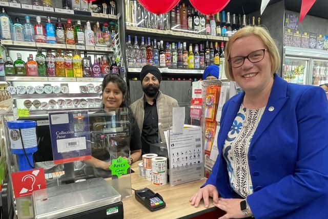 Zöe Franklin MP being served by postmaster Kiranjeet Singh and employee Priyanka Sawant.