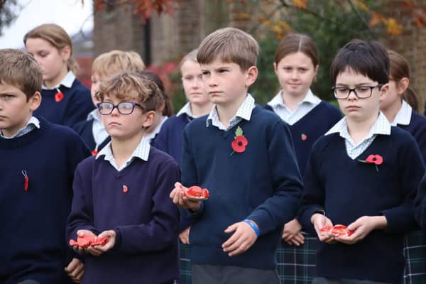 Highfield and Brookham pupils hold their ceramic poppies during the Act of Remembrance. Picture: Highfield and Brookham School