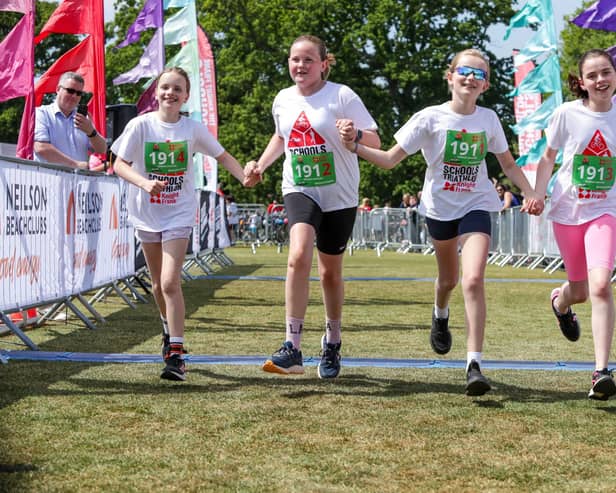 A team crossing the finish line of the Knight Frank Schools Triathlon
