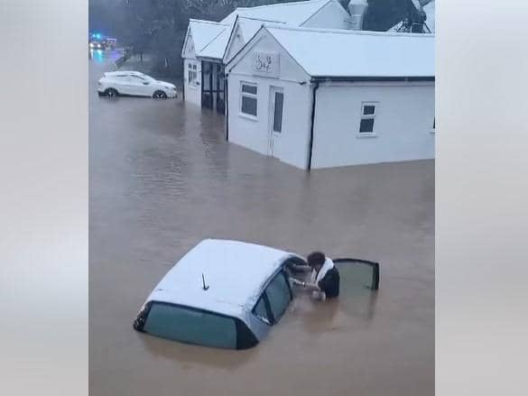 Woman is pulled from car during heroic flood rescue