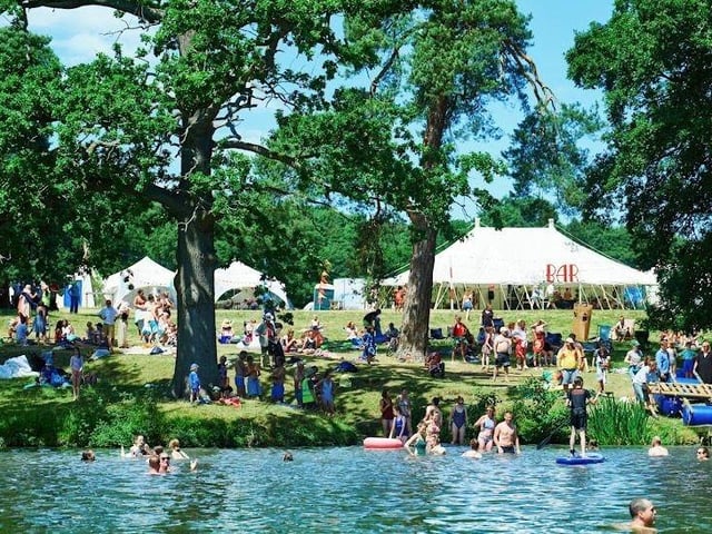 The beautiful lake at ALSO Festival in Compton Verney where people paddleboard, wild swim and do yoga