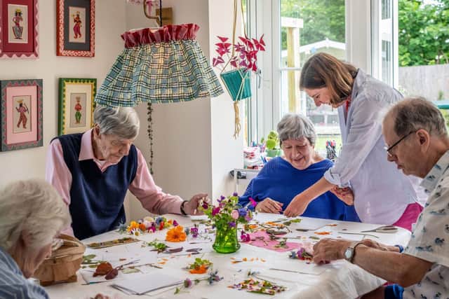 Tapestry Day Club guests enjoy creating cards with flowers from their host's garden