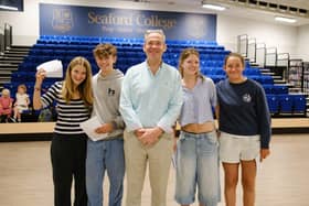 Headmaster John Green with Eva Briscoe, Lottie Curling and students celebrating GCSE success.
