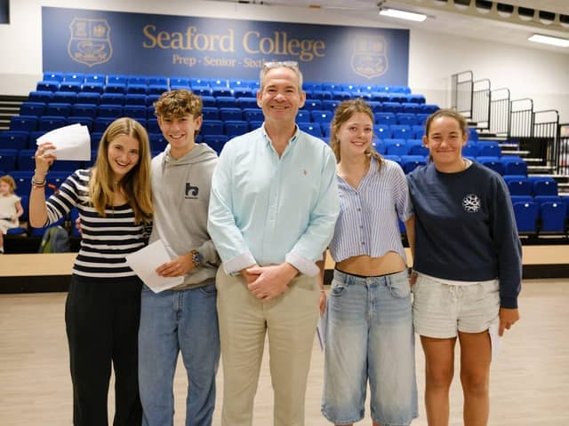 Headmaster John Green with Eva Briscoe, Lottie Curling and students celebrating GCSE success.