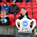 A fan of Brighton & Hove Albion fan holding a cut out of the FA Cup at Stoke City