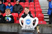 A fan of Brighton & Hove Albion fan holding a cut out of the FA Cup at Stoke City