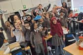 Chestnut Park students holding their new trainers aloft