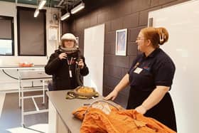 An Alton College student tries on a space helmet.