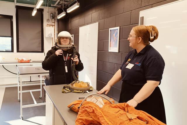 An Alton College student tries on a space helmet.
