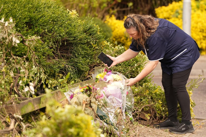 Flowers are being placed at the scene where a young woman died and her sister and cousin were seriously injured during a collision with a BMW