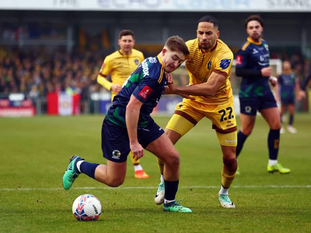 SUTTON, ENGLAND - DECEMBER 02: Joe Kizzi of Sutton United tackles Charlie Hester-Cook of Horsham during the Emirates FA Cup Second Round match between Sutton United and Barnsley at VBS Community Stadium on December 02, 2023 in Sutton, England. (Photo by Bryn Lennon/Getty Images)
