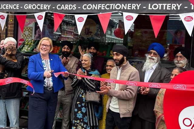 Zöe Franklin MP "cuts the ribbon" at the official opening of Merrow Post Office.