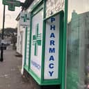 Outside South Street Pharmacy, Dorking, with protest poster in the window. (Credit: Emily Dalton/LDRS)