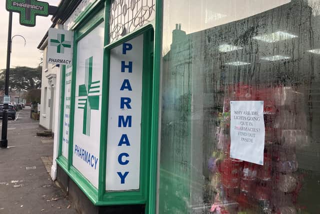 Outside South Street Pharmacy, Dorking, with protest poster in the window. (Credit: Emily Dalton/LDRS)