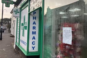 Outside South Street Pharmacy, Dorking, with protest poster in the window. (Credit: Emily Dalton/LDRS)