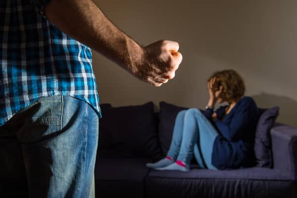PICTURE POSED BY MODEL A man stands with a clenched fist as a woman cowers in the corner.