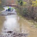 Heavy flooding on B2115 Warninglid Lane in Horsham, with a resident helping to clear the water. Photo: Eddie Mitchell