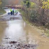 Heavy flooding on B2115 Warninglid Lane in Horsham, with a resident helping to clear the water. Photo: Eddie Mitchell