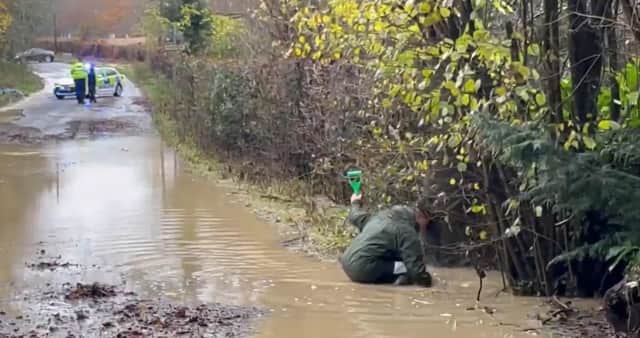 Heavy flooding on B2115 Warninglid Lane in Horsham, with a resident helping to clear the water. Photo: Eddie Mitchell