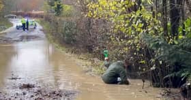 Heavy flooding on B2115 Warninglid Lane in Horsham, with a resident helping to clear the water. Photo: Eddie Mitchell